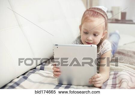 Caucasian girl using digital tablet View Large Photo Image Stock Photography - Caucasian girl using digital tablet. Fotosearch