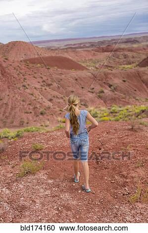 Stock Image - Caucasian girl walking on rural hilltop. Fotosearch