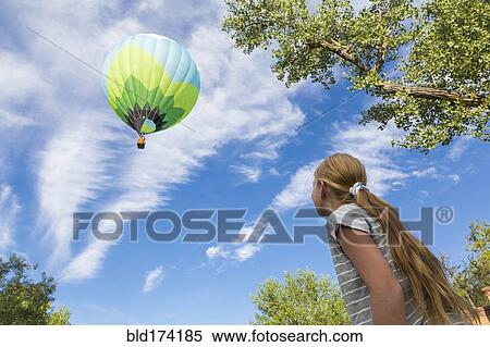 Stock Photography - Caucasian girl watching hot air balloon. Fotosearch