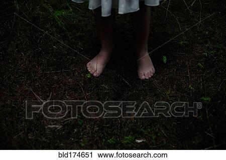 Stock Image - Caucasian girl with bare feet in dirt. Fotosearch