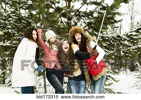 Stock Photography - Caucasian girls taking selfie in snow. Fotosearch