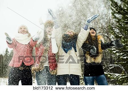 Caucasian girls tossing snow in air View Large Photo Image Stock Image - Caucasian girls tossing snow in air. Fotosearch
