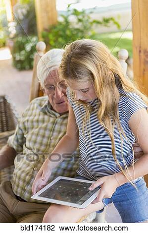 Caucasian grandfather and granddaughter using digital tablet View Large Photo Image Stock Image - Caucasian grandfather and granddaughter using digital tablet. Fotosearch