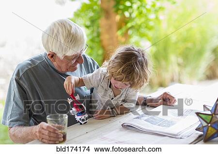 Picture - Caucasian grandfather and grandson playing with toy helicopter. Fotosearch