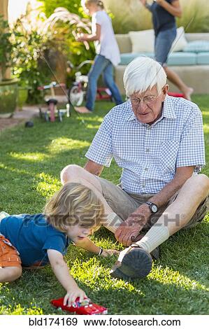 Stock Photo - Caucasian grandfather and grandson playing on lawn. Fotosearch
