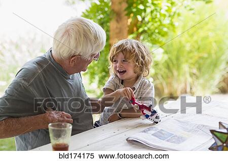Stock Photography - Caucasian grandfather and grandson playing with toy helicopter. Fotosearch