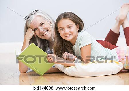Stock Photo - Caucasian grandmother and granddaughter reading book. Fotosearch