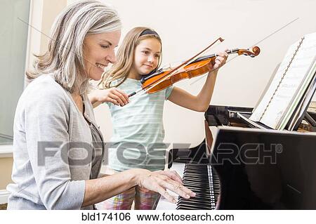 Caucasian grandmother and granddaughter playing music together View Large Photo Image Stock Photograph - Caucasian grandmother and granddaughter playing music together. Fotosearch