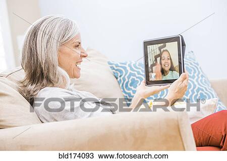 Caucasian grandmother videochatting with granddaughter on digital tablet View Large Photo Image Stock Image - Caucasian grandmother videochatting with granddaughter on digital tablet. Fotosearch