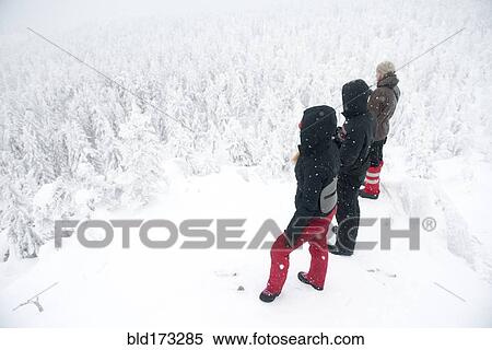 Caucasian hikers on mountaintop admiring snowy forest View Large Photo Image Stock Photography - Caucasian hikers on mountaintop admiring snowy forest. Fotosearch