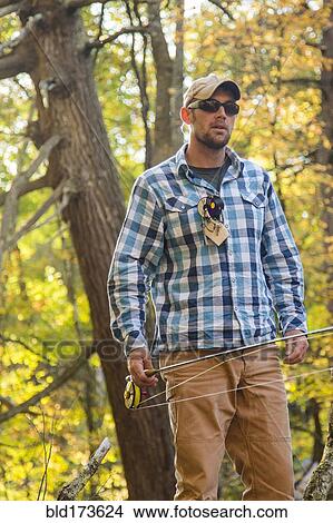 Caucasian man carrying fishing rod under tree View Large Photo Image Picture - Caucasian man carrying fishing rod under tree. Fotosearch