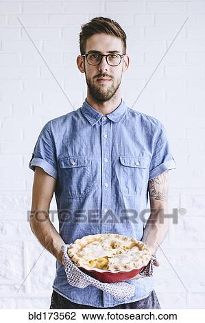 Stock Image - Caucasian man holding peach pie. Fotosearch