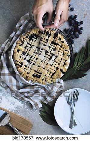 Caucasian man slicing blueberry pie View Large Photo Image Stock Photo - Caucasian man slicing blueberry pie. Fotosearch