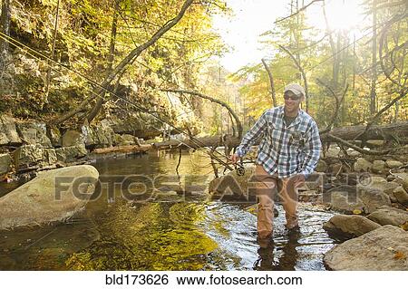 Caucasian man walking in forest stream View Large Photo Image Stock Photograph - Caucasian man walking in forest stream. Fotosearch