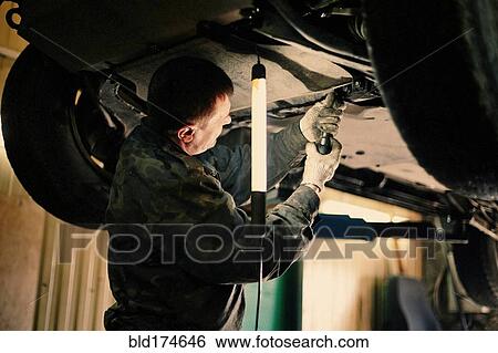 Caucasian mechanic fixing car View Large Photo Image Stock Photograph - Caucasian mechanic fixing car. Fotosearch