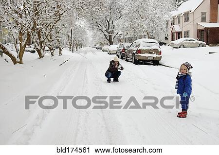 Stock Image - Caucasian mother and son playing in snow. Fotosearch