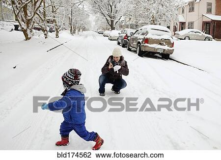 Stock Image - Caucasian mother and son playing in snow. Fotosearch