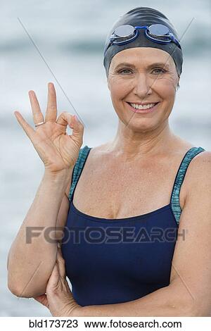 Stock Image - Caucasian swimmer making OK sign. Fotosearch