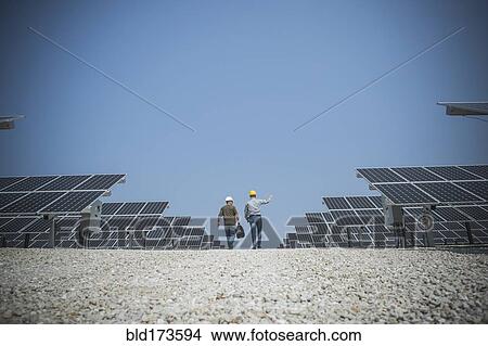Caucasian technicians talking near solar panels View Large Photo Image Picture - Caucasian technicians talking near solar panels. Fotosearch