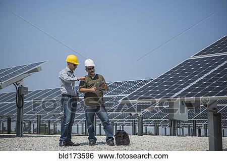 Caucasian technicians talking near solar panels View Large Photo Image Stock Photograph - Caucasian technicians talking near solar panels. Fotosearch