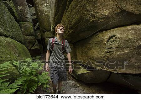 Picture - Caucasian teenage boy exploring cave. Fotosearch