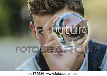 Stock Photograph - Caucasian teenage boy holding crystal ball. Fotosearch