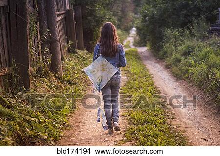 Caucasian teenage girl carrying kite on dirt road View Large Photo Image Picture - Caucasian teenage girl carrying kite on dirt road. Fotosearch