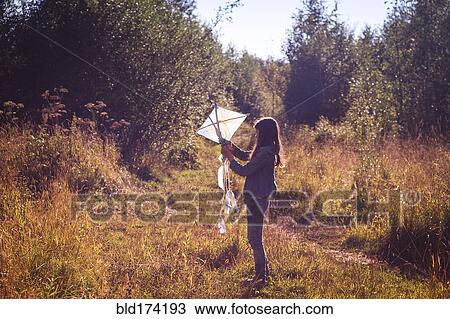 Caucasian teenage girl holding kite in field View Large Photo Image Stock Image - Caucasian teenage girl holding kite in field. Fotosearch