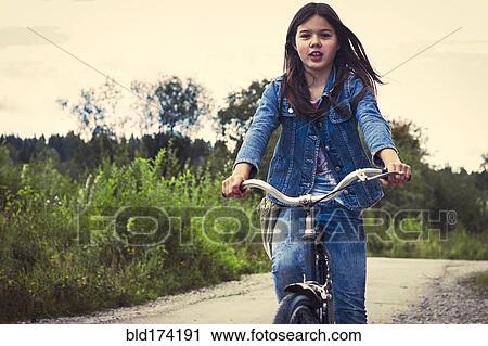 Stock Image - Caucasian teenage girl riding bicycle. Fotosearch
