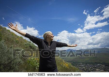 Caucasian woman cheering on rural hillside View Large Photo Image Stock Image - Caucasian woman cheering on rural hillside. Fotosearch