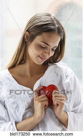 Stock Image - Caucasian woman holding heart. Fotosearch