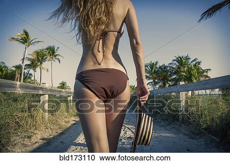 Stock Image - Caucasian woman in bikini on beach. Fotosearch