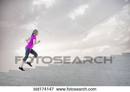 Stock Photo - Caucasian woman jogging on steps. Fotosearch