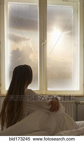 Stock Photography - Caucasian woman looking out window. Fotosearch