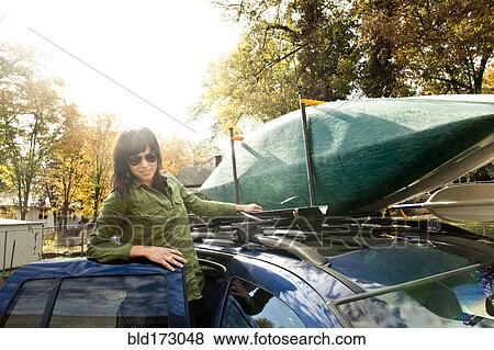 Caucasian woman packing kayak on car View Large Photo Image Stock Photo - Caucasian woman packing kayak on car. Fotosearch