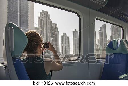 Caucasian woman photographing Dubai cityscape on train, Dubai Emirate, United Arab Emirates View Large Photo Image Stock Photography - Caucasian woman photographing Dubai cityscape on train, Dubai Emirate, United Arab Emirates. Fotosearch