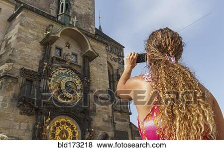 Stock Photo - Caucasian woman photographing ornate church, Prague, Prague, Czech Republic. Fotosearch