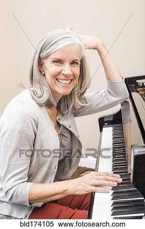 Stock Photography - Caucasian woman playing piano. Fotosearch