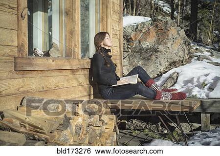 Caucasian woman reading book on cabin porch View Large Photo Image Stock Photograph - Caucasian woman reading book on cabin porch. Fotosearch