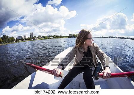 Stock Image - Caucasian woman rowing boat. Fotosearch
