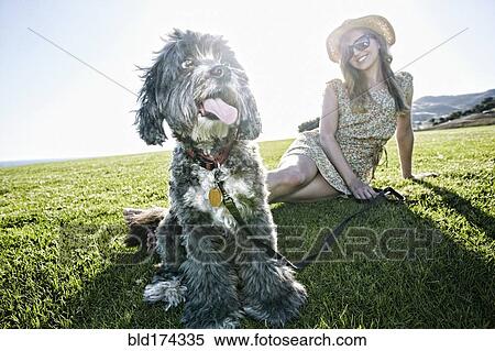 Caucasian woman sitting in field with dog View Large Photo Image Stock Photography - Caucasian woman sitting in field with dog. Fotosearch