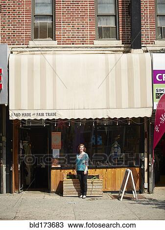 Stock Image - Caucasian woman standing outside store. Fotosearch