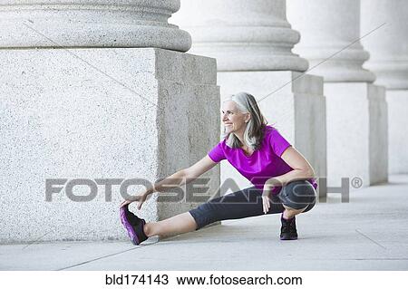 Caucasian woman stretching outside courthouse View Large Photo Image Stock Image - Caucasian woman stretching outside courthouse. Fotosearch
