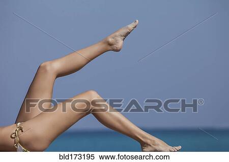 Stock Photography - Caucasian woman sunbathing under blue sky. Fotosearch