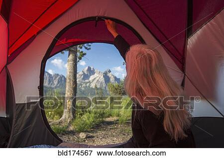 Stock Photo - Caucasian woman unzipping tent. Fotosearch