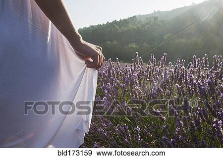 Caucasian woman walking in field of flowers View Large Photo Image Stock Photo - Caucasian woman walking in field of flowers. Fotosearch