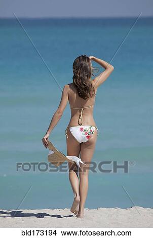 Picture - Caucasian woman walking on beach. Fotosearch