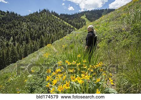 Stock Photo - Caucasian woman walking on remote hillside. Fotosearch