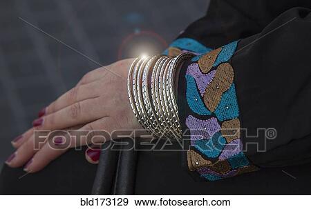 Stock Photo - Caucasian woman wearing gold bracelets. Fotosearch