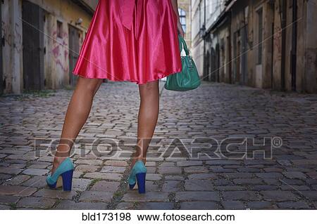 Stock Photo - Caucasian woman wearing heels in alleyway. Fotosearch